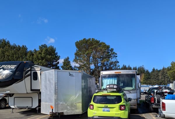 RV and trailer backed into site with lime green jeep in front