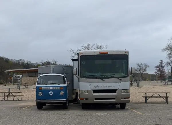 big rig RV parked in campsite next to VW bus