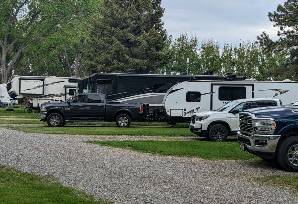 Monthly rates at RV parks can allow you to stay at places like this RV park. Image includes several fifth wheels and pickup trucks.