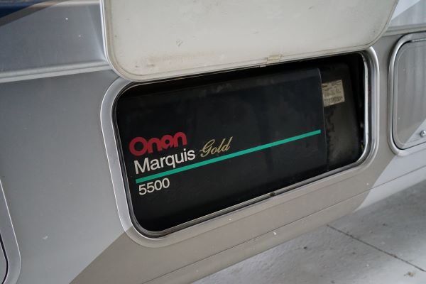 Camper with generator compartment open to show the brand-- Onan 5500.