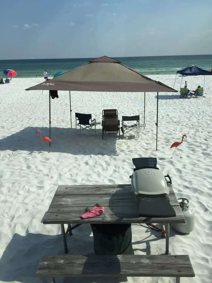 Camp Gulf Florida RV beach resort right on the sand. A sun shade canopy and grill are pictured in front of the ocean