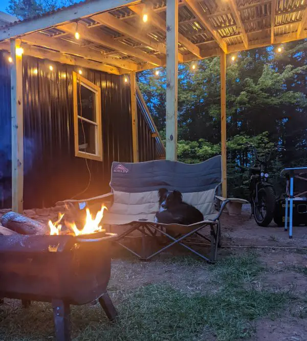 Kelty low loveseat camp chair by the fire with our dog Luna sitting in it